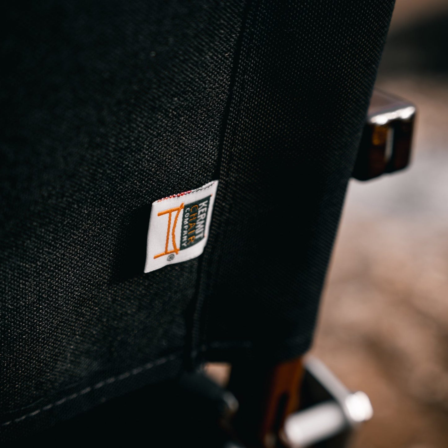 close up detail shot of a kermit chair in walnut with black 1000D fabric luxury camping glamping wooden heritage furniture handmade in USA